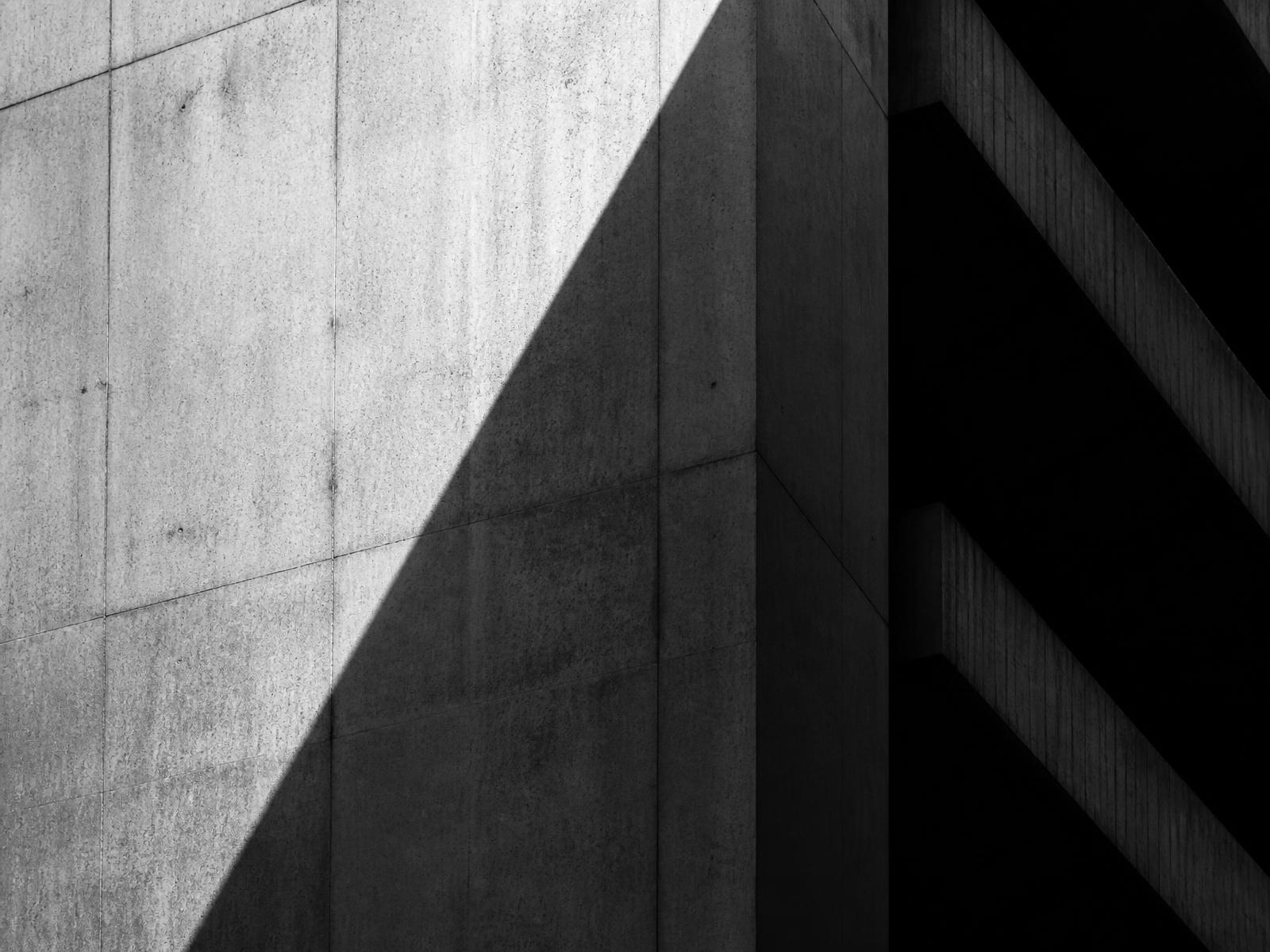Monolithic concrete facade cut by hard diagonal light